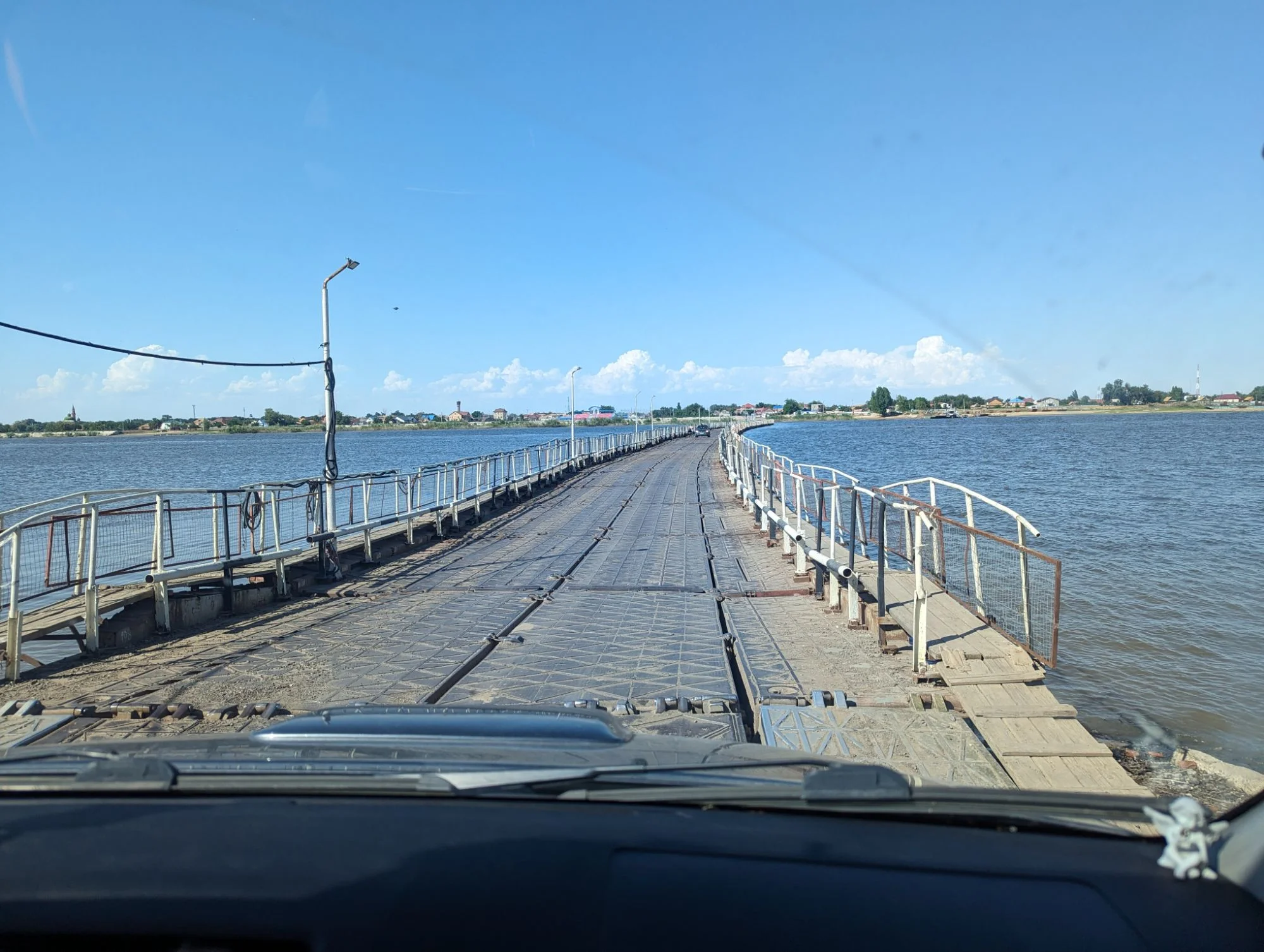 This was a  floating bridge which was constantly pushed to the side by the river. On one end of it they installed a couple of outboard motors to keep it in place.