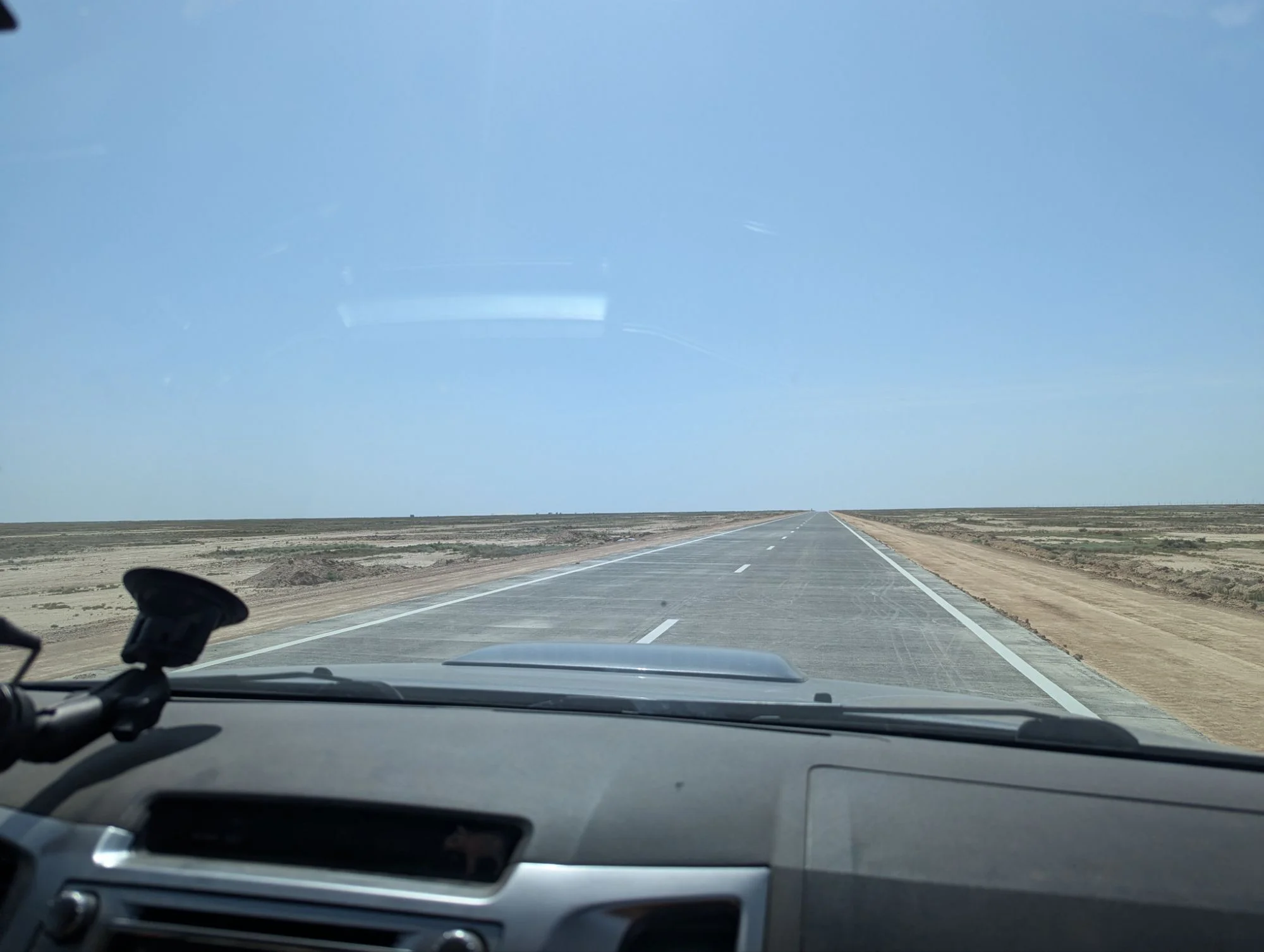 From Kazakhstan we took the border crossing to Uzbekistan. The road after the crossing was the worst we’ve ever experienced. This photo shows the new road which was still in construction. But we illegally crossed from the old, broken road to this one because the old one was so crazy. Before we tried to go next to the broken road through the dirt and dust but that worked not as good as well. On iOverlander there are reports of travelers going ten kilometers per hour on 250km of distance. We could go much faster but still it was crazy. I got really mad about this. And it’s weird: on an off-road track I don’t mind going slow, but on this road… The potholes were so deep, big and there were so many. And there were trucks. A lot. They had to go really slow, nearly stopping. If the locals go like that, you know about the conditions of a road. We’ve never seen so many cars broken at the side of the road. At some point I started just acceleration and braking hard because I just wanted to pass this road. Didn’t make sense but… fuck it!